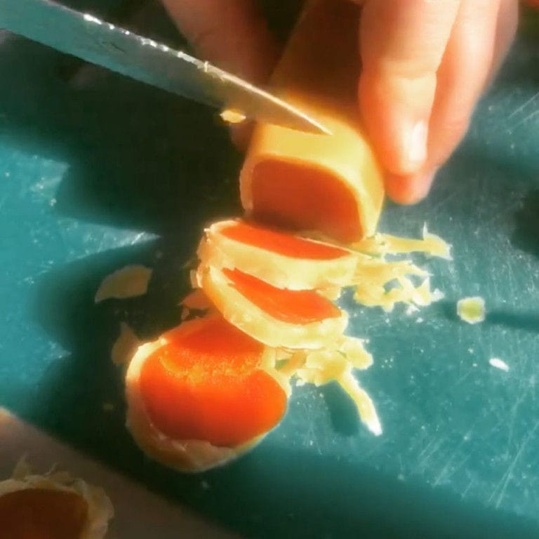 man cutting dry slices of avgotaraho at Bottarga Stefos